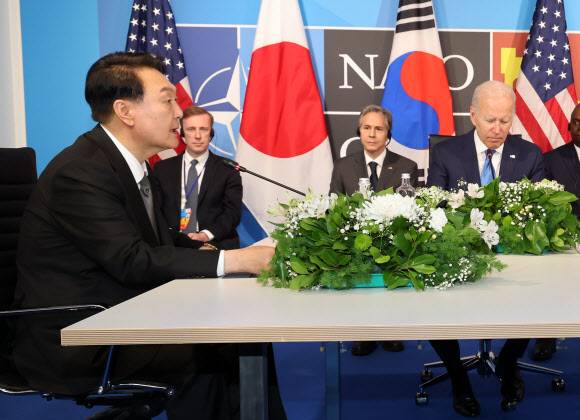 윤석열 대통령이 29일 스페인 마드리드 이페마(IFEMA) 컨벤션센터에서 열린 한미일 정상회담에서 조 바이든 미국 대통령, 기시다 후미오 일본 총리와 대화하고 있다.연합뉴스