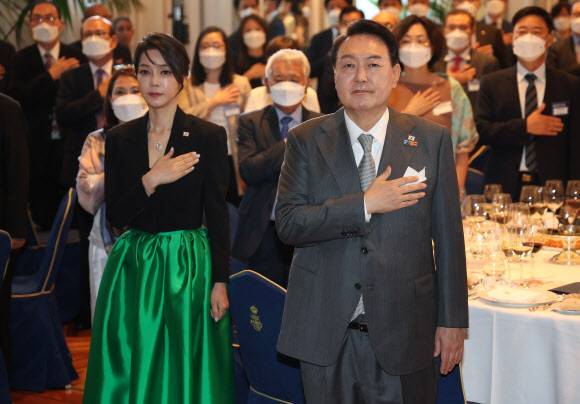 국기에 경례하는 윤석열 대통령 내외 - 윤석열 대통령과 김건희 여사가 29일(현지시간) 스페인 마드리드 만다린 오리엔탈 리츠호텔에서 열린 동포 만찬간담회에서 국기에 경례를 하고 있다.  2022.6.30 연합뉴스