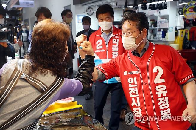 인천 소래포구서 지지 호소하는 유정복 후보 (인천=연합뉴스) 윤태현 기자 = 6·1 지방선거 인천시장에 출마한 국민의힘 유정복 후보가 26일 오후 인천시 남동구 소래포구 종합어시장에서 한 상인과 인사하며 지지를 호소하고 있다. 2022.5.26 tomatoyoon@yna.co.kr