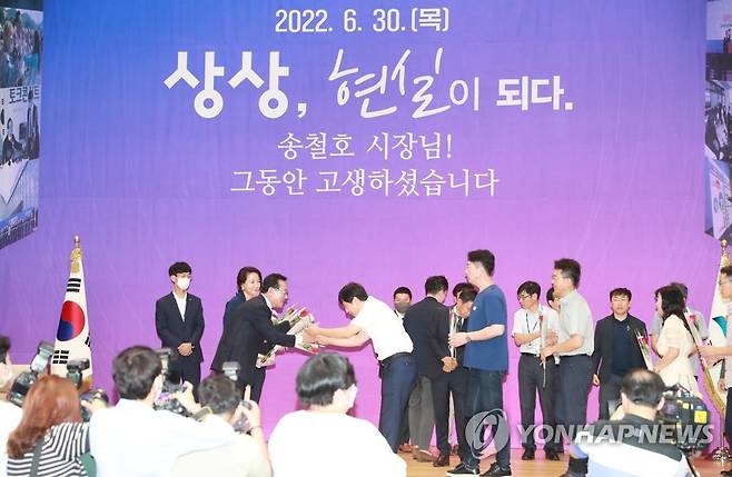 이임하는 송철호 울산시장 (울산=연합뉴스) 30일 오전 울산시청 대강당에서 열린 민선 7기 송철호 울산시장 이임식에서 송 시장이 직원들에게 장미꽃을 받으며 인사를 나누고 있다. 2022.6.30 [울산시 제공. 재판매 및 DB 금지] hkm@yna.co.kr