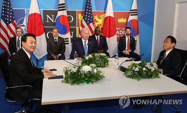 어색한 한일 정상 (마드리드=연합뉴스) 서명곤 기자 = 윤석열 대통령이 29일 스페인 마드리드 이페마(IFEMA) 컨벤션센터에서 열린 한미일 정상회담에서 조 바이든 미국 대통령, 기시다 후미오 일본 총리와 대화하고 있다.  2022.6.29 seephoto@yna.co.kr