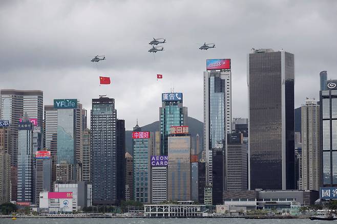 홍콩의 중국반환 25주년인 1일 중국 국기와 홍콩기를 매단 헬기들이 홍콩 빅토리아 항의 고층빌딩 위로 축하비행하고 있다./로이터 연합뉴스