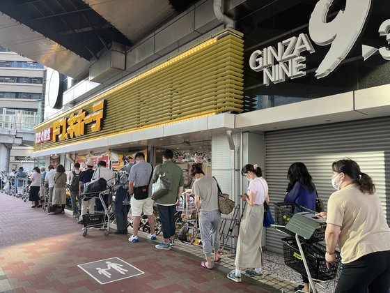 지난달 29일 일본 도쿄 긴자의 한 대형 할인점 앞에 최대 75%를 할인해 파는 '타임 세일' 시간에 맞춰 줄이 늘어서있다. 사진 김현예 특파원