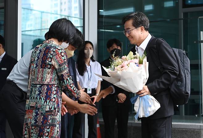 김동연 경기도지사가 1일 오전 경기도 수원시 경기도청으로 첫 출근을 하며 직원으로부터 꽃다발을 받고 있다. 연합뉴스