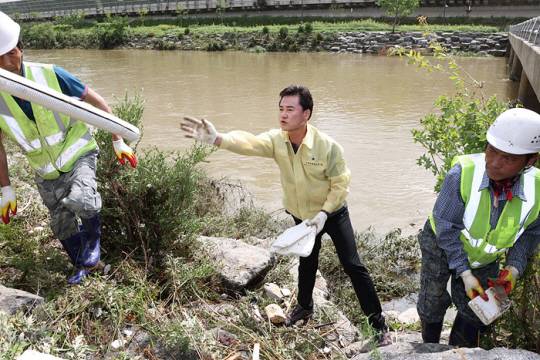 오언석 도봉구청장이 취임 첫날인 1일 오전 큰비로 인해 물이 범람한 중랑천변을 찾아 현장을 점검하고 청소에 나섰다. 도봉구청 제공