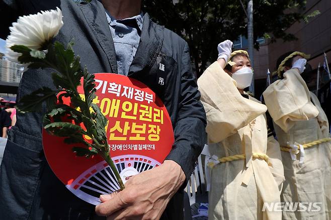 [서울=뉴시스] 백동현 기자 = 1일 오전 서울 용산구 삼각지역 인근에 열린 발달·중증장애인 참사 T4장례식에서 유족들이 구호를 외치고 있다. 2022.07.01. livertrent@newsis.com