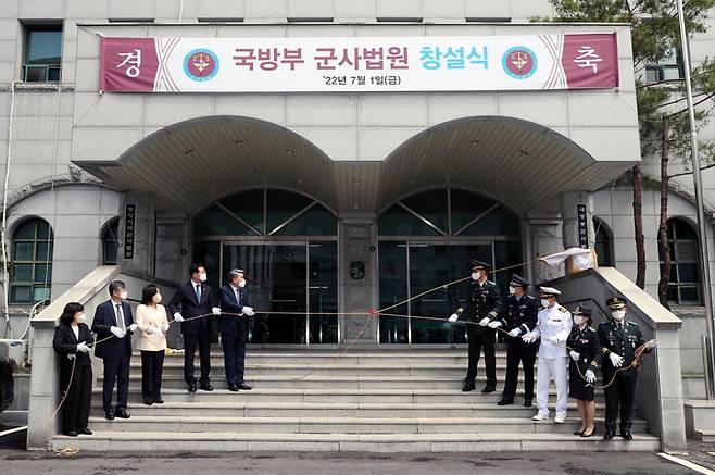 [서울=뉴시스]  이종섭 국방부장관(왼쪽에서 5번째)이 1일 오전 국방부 군사법원 대법정에서 열린 중앙지역 군사법원 창설식에서 창설군사법원장(대열 오른쪽 5명) 및 주요 외빈(대열 왼쪽 중앙에서부터 민홍철 의원, 전주혜 의원, 김광태 서울고등법원장, 유재은 국방부 법무관리관 순)들과 현판식을 하는 모습. 2022.07.01. (사진=국방일보 제공) *재판매 및 DB 금지