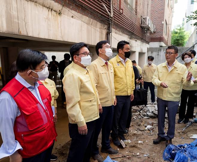박강수(왼쪽 두 번째) 서울 마포구청장이 민선 8기 임기 첫 날인 1일 최근 집중 호우로 담장이 붕괴된 서교동을 방문해 구청 관계자로부터 현장 상황에 대한 설명을 듣고 있다.마포구 제공