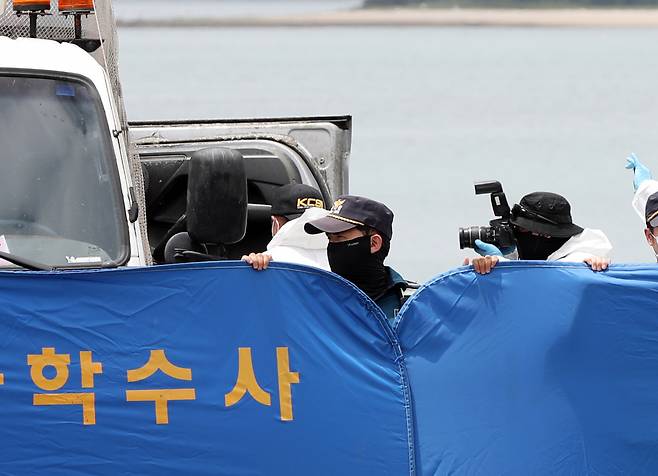 지난 달 29일 오전 전남 완도군 신지면 송곡선착장 인근 방파제에서 경찰이 10ｍ 바닷속에 잠겨있는 조유나(10)양 가족의 차량을 인양한 뒤 차량 내부를 촬영하고 있다. 경찰은 실종된 조양의 가족과 차량을 찾기 위해 수중 수색하다 전날 가두리양식장 아래에 잠겨있는 차량을 발견했다. [연합]