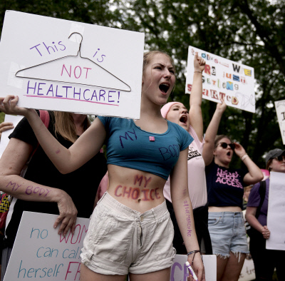 판결에 분노한 민심 여전 미국 미주리주 캔자스시티에서 임신중단권 폐기에 반대하는 시민들이 임신중단이 불법이었던 시절 음성적인 임신중단 도구로 사용된 ‘옷걸이’가 그려진 손팻말을 들고 항의 집회를 하고 있다. 캔자스시티 | AP연합뉴스