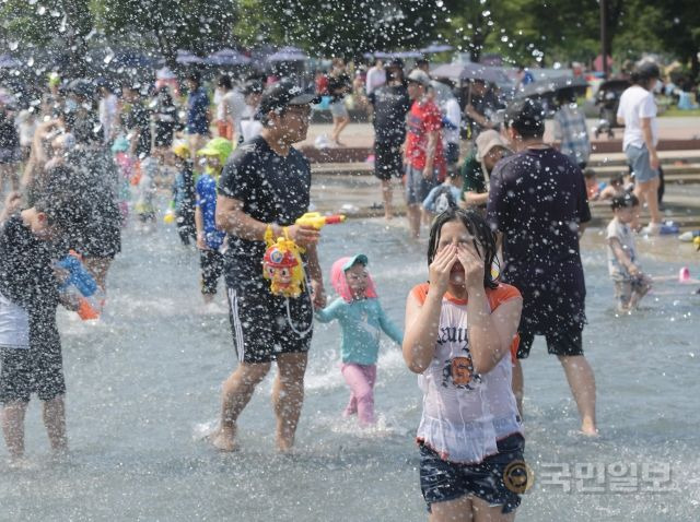 서울의 낮기온이 33도까지 오르며 무더위가 이어지고 있는 3일 서울 영등포구 여의도한강공원 물빛광장을 찾은 시민들이  물놀이를 하고 있다.