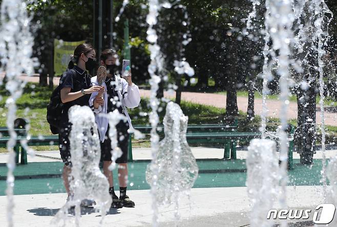 폭염주의보가 발효된 4일 부산 남구 평화공원 바닥분수를 지나는 학생들이 물줄기를 바라보며 더위를 식히고 있다. 2022.7.4/뉴스1 © News1 김영훈 기자