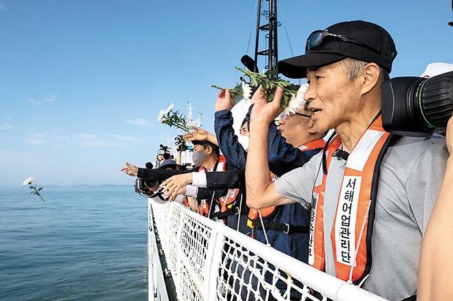 피살 공무원 위령제 - 서해에서 북한군에 사살당한 해양수산부 공무원 이대준씨의 형 이래진(오른쪽)씨가 2일 연평도 인근 사고 현장에서 열린 선상 위령제에서 바다를 향해 흰 국화를 던지고 있다. /뉴스1