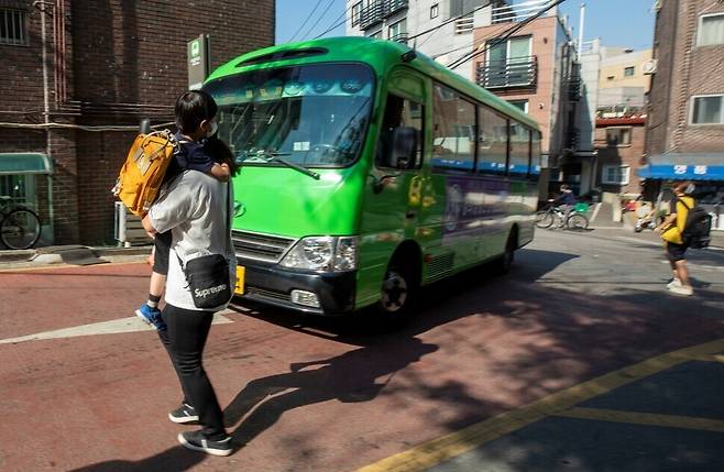 지난달 31일 서울 성동구에 사는 발달장애 아동 우진(가명)이가 엄마 품에 안겨 마을버스를 타러 가고 있다. 김진수 선임기자 jsk@hani.co.kr