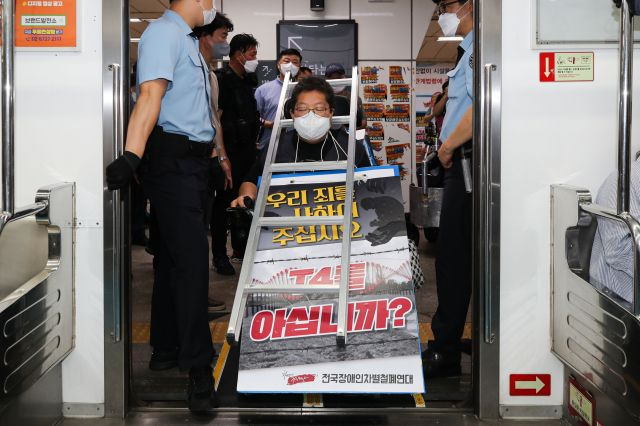 전국장애인차별철폐연대가 4일 오전 서울 용산구 삼각지역에서 장애인 권리 예산 보장 등을 요구하며 '제33차 출근길에 지하철 탑니다’ 시위를 하고 있다. 뉴시스