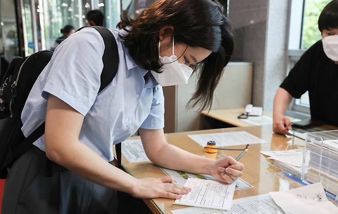 박지현 전 더불어민주당 비상대책위원장이 1일 서울 여의도 국회 의원회관에서 열린 그린벨트 결과 공유 파티 '용감한 여정'에 참석하기 위해 방문 신청서를 작성하고 있다. 연합뉴스