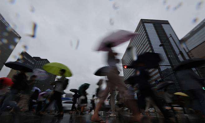 우산을 쓴 시민들이 서울 광화문 사거리를 지나고 있다. 연합뉴스