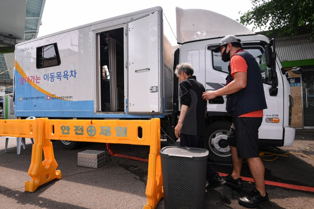 한 주민이 5일 서울 영등포구 쪽방촌 앞의 이동목욕차를 이용하기 위해 들어서고 있다. 이한결 기자