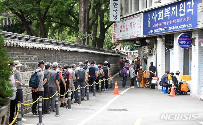 [서울=뉴시스] 이영환 기자 = 폭염이 이어지고 있는 5일 오전 서울 종로구 탑골공원 인근 무료급식소를 찾은 어르신들이 대기하고 있다. 2022.07.05. 20hwan@newsis.com