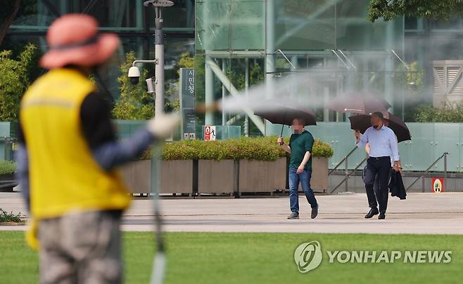 차라리 비가 그리운 날씨 (서울=연합뉴스) 김도훈 기자 = 찜통더위가 계속되고 있는 4일 오후 서울광장에서 햇볕을 피해 양산을 든 외국인들이 길을 지나고 있다. 2022.7.4 superdoo82@yna.co.kr