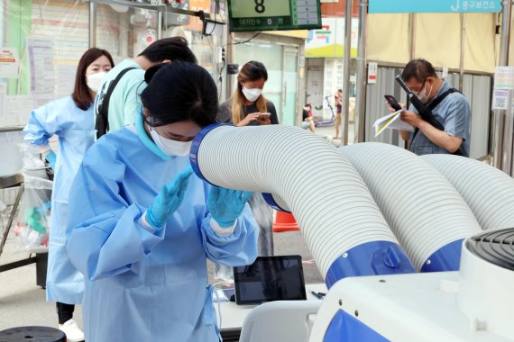 코로나와 폭염과 사투. 폭염과 함께 코로나19 확진자가 1만9000여명을 기록한 6일 서울 중구보건소 선별진료소에서 의료진이 냉풍기로 더위를 식히고 있다. 사진=박범준 기자