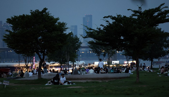 지난 5일 오후 서울 영등포구 여의도한강공원을 찾은 시민들이 더위를 식히는 모습. 〈사진-연합뉴스〉