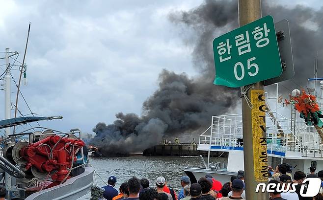 7일 오전 제주시 한림읍 한림항 안에 정박 중이던 어선 3척에서 불이나 많은 연기가 발생하자 인근 주민들이 현장을 지켜보고 있다. 현재 이 화재로 3명이 다쳐 병원에 이송 중이다. 2022.7.7/뉴스1 © News1 오현지 기자