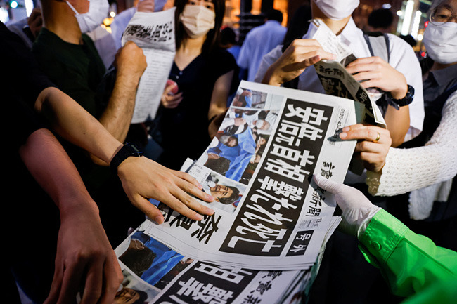 8일 오후 일본 도쿄에서 아베 신조 전 총리의 사망 소식을 전하는 요미우리 신문 호외를 시민에게 나눠주고 있다. 로이터연합뉴스