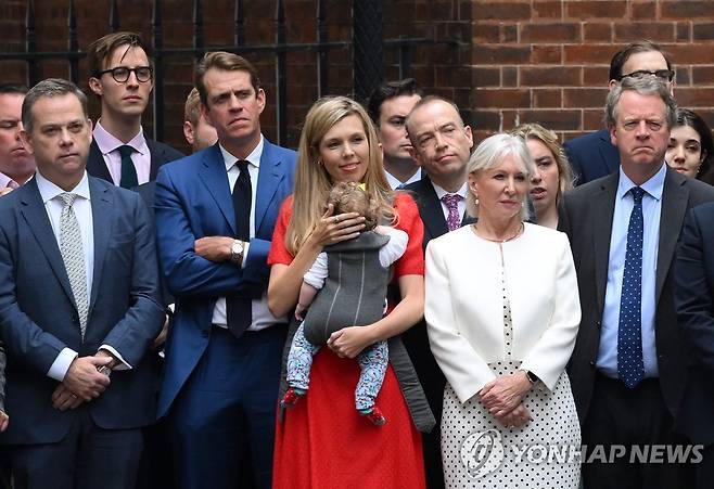 둘째 딸 안고 존슨 총리 사임발표 보는 캐리 존슨 여사(빨간색 옷)(AFP=연합뉴스)