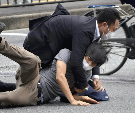 지난 8일 일본 나라현 나라시에서 선거 유세활동을 하던 아베 신조 전 일본 총리(68)를 총기로 저격한 용의자 야마가미 데쓰야(41)가 범행 직후 제압당하고 있다. [요미우리신문=AP]