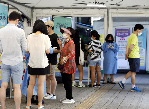 코로나19 확진자수가 0시 기준 1만59명을 기록한 3일 서울 용산구보건소 선별진료소를 찾은 시민들이 검사를 받기 위해 대기하고 있다. 지난 3월 이후 꾸준히 감소하며 6월10일 네자릿수를 기록했던 신규 확진자수가 같은달 29일 다시 1만명대로 올라섰다. 방역당국은 코로나19 유행 감소세가 한계에 도달한 상황으로 보고 당분간 다소 증가와 감소를 반복할 것으로 내다보고 있다. 2022.07.03. 뉴시스