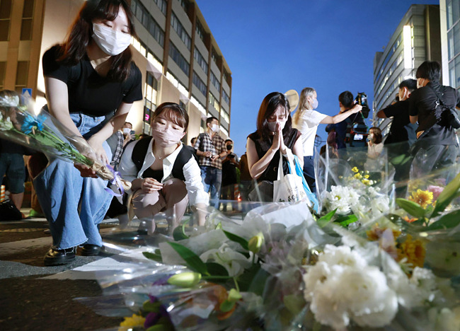 일본 시민들이 지난 9일 나라현 총격 현장에 꽃을 놓으며 아베 신조 전 일본 총리의 죽음을 애도하고 있다. 교도통신AP뉴시스