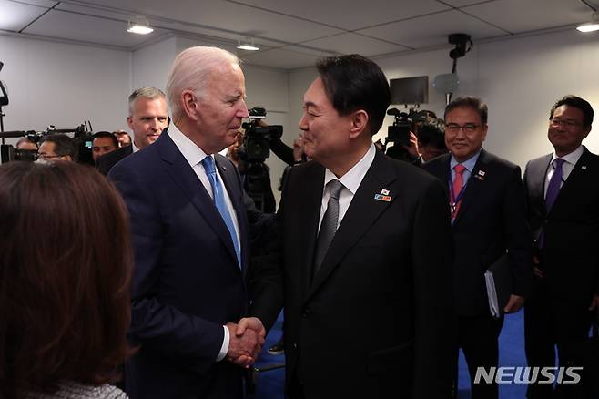 [서울=뉴시스] 대통령실이 3일 윤석열 대통령과 부인 김건희 여사의 나토(NATO·북대서양조약기구) 정상회의 순방 사진을 추가 공개했다. 사진은 윤석열 대통령이 지난 29일(현지시간) 스페인 마드리드 이페마(IFEMA)에서 조 바이든 미국 대통령과 한미일 정상회담에 앞서 악수하는 모습. (사진=대통령실 제공) 2022.07.03. photo@newsis.com