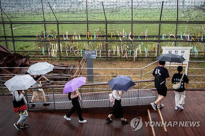 지난 8일 경기도 파주시 임진각에서 방문객들이 우산을 쓴 채 한국전쟁 당시 파괴된 증기기관차 파편을 둘러보며 이동하고 있다. [연합뉴스 자료사진]