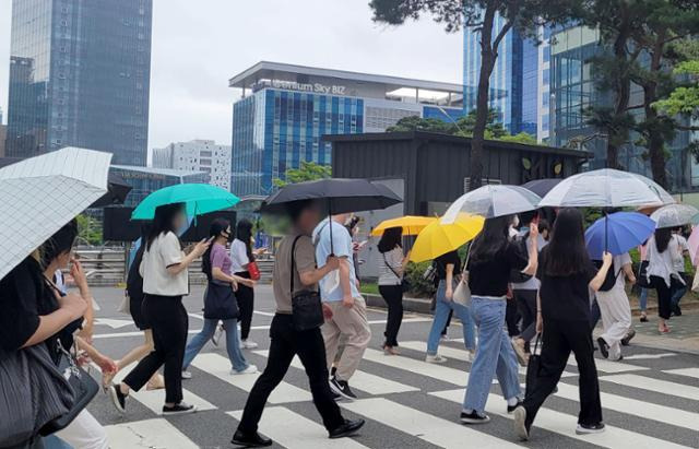 8일 오전 부산 해운대구 센텀시티에서 직장인들이 갑자기 비가 내리자 우산을 쓰고 출근하고 있다. 연합뉴스