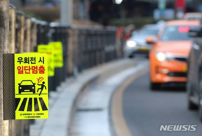 [서울=뉴시스] 배훈식 기자 = 16일 오전 서울시내 한 교차로에 우회전 시 보행자 안전을 위한 일단 멈춤 표시가 설치돼 있다. 경찰청은 지난 11일 '교차로 일단 정지'를 골자로 하는 도로교통법 개정안을 공포하고 오는 7월12일부터 시행할 예정이다. 2022.01.16. dahora83@newsis.com