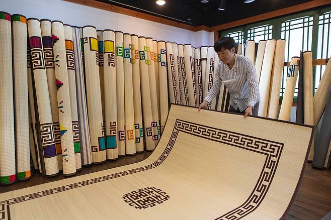 1600년 전통을 자랑하는 화문석은 강화도의 대표 특산물이다. 공장에서 만든 수입산 돗자리와 달리 강화도에서 직접 재배한 왕골을 말려 60만 번의 손길을 거쳐야 사진 속 화문석이 탄생한다. 강화도령 화문석 박윤환 대표가 6자짜리 화문석을 펼쳐보이는 모습. 최승표 기자