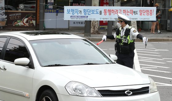 횡단보도 앞 일시정지 등 보행자 보호 의무를 강화한 도로교통법 개정안 시행 첫날인 12일 서울 종로구 이화사거리에서 경찰들이 계도에 나서고 있다. 뉴스1