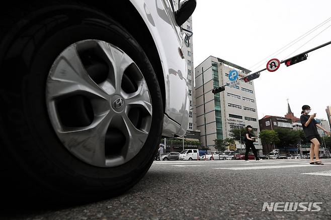 [서울=뉴시스] 백동현 기자 = 횡단보도 앞 일시정지 의무를 확대하는 등 보행자 보호의무가 강화된 도로교통법 시행 첫날인 12일 오후 서울 시내 한 횡단보도에서 차량이 보행자의 횡단을 기다리고 있다. 2022.07.12. livertrent@newsis.com