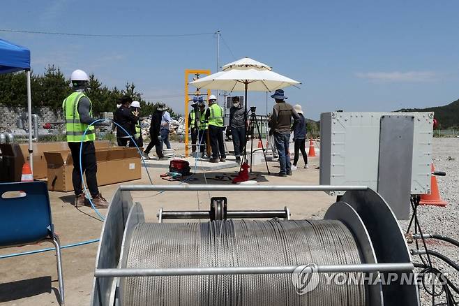 와이어 줄에 연결 (포항=연합뉴스) 손대성 기자 = 지난 5월 11일 경북 포항시 북구 흥해읍 포항지열발전 부지에서 영국인 기술자와 작업자들이 지열정 속에 지진계를 설치하고 있다.
    포항지열발전은 2017년 11월 규모 5.4 포항지진을 촉발한 곳이다. 2022.5.11 sds123@yna.co.kr