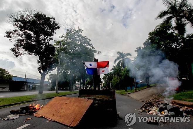 "기름값 내려라" 파나마서 격한 시위 (파나마시티 AFP=연합뉴스) 11일(현지시간) 파나마 수도 파나마시티에서 한 시민이 유류비 인하를 요구하는 도로 봉쇄 시위를 하며 국기를 들고 있다. 2022.7.12