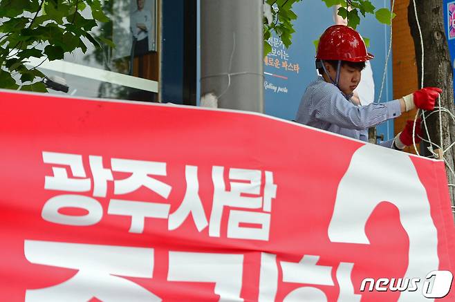 이준석 국민의힘 대표가 20일 오전 광주 북구 용봉동 전남대학교 후문 앞 도로에서 당 소속 6·1지방선거 후보자들의 훼손된 현수막을 다시 걸고 있다. 2022.5.20/뉴스1 © News1 정다움 기자