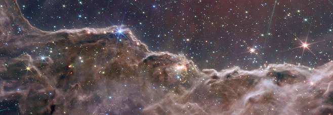12일 NASA에서 공개한 우주망원경 '제임스 웹' JWST(James Webb Space Telescope)의 근적외선 카메라(NIRCam)와 중적외선 기기(MIRI)가 포착한 정보를 합성한 이미지. 용골 성운의 NGC 3324라고 불리는 근처의 젊고 별이 생성되는 영역의 가장자리인 반짝이는 별들로 이루워져있다./NASA