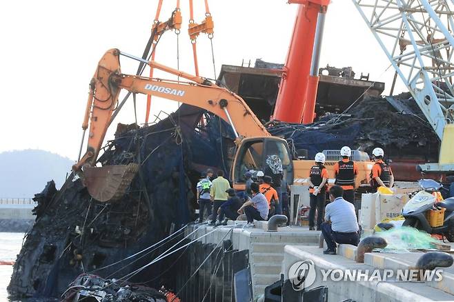 인양된 제주 한림항 최초 화재 어선 (제주=연합뉴스) 백나용 기자 = 13일 오후 제주시 한림항에서 제주시와 해경 관계자들이 지난 7일 불이 난 한림 선적 근해채낚기 어선 A호(29t)를 사고 현장 인근 물양장 위에 놓고 있다. dragon.me@yna.co.kr