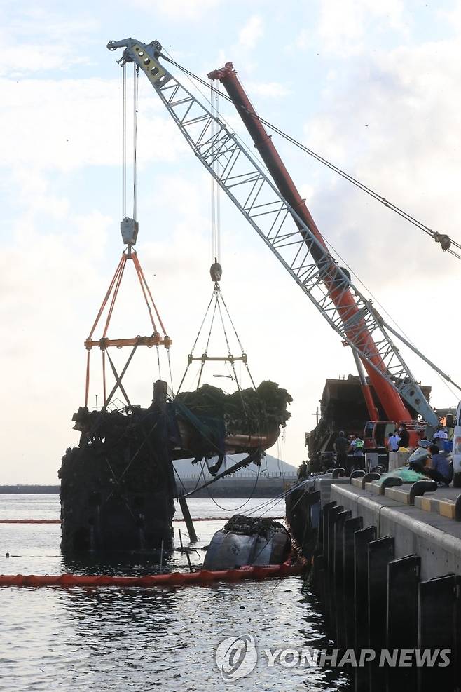 인양되는 제주 한림항 최초 화재 어선 (제주=연합뉴스) 백나용 기자 = 13일 오후 제주시 한림항에서 제주시와 해경 관계자들이 지난 7일 불이 난 한림 선적 근해채낚기 어선 A호(29t)를 인양하고 있다. 2022.7.13 dragon.me@yna.co.kr