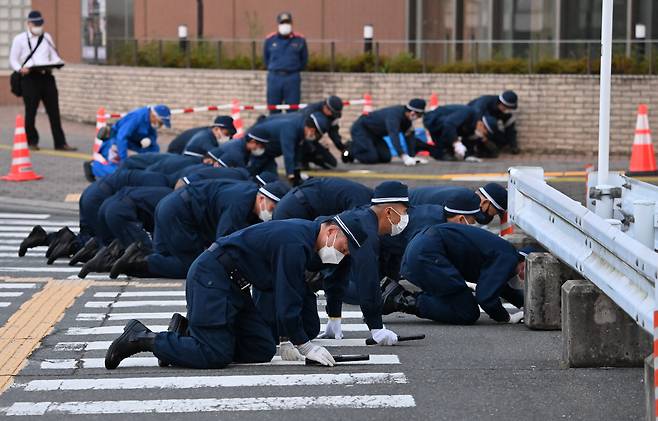 아베 신조 전 총리 암살 사건을 수사 중인 일본 나라현 경찰본부 감식원들이 13일 사건 현장인 나라시 야마토사이다이 일대에서 무릎을 끓고 이동하며 총알과 탄흔을 찾고 있다. 아사히신문 제공