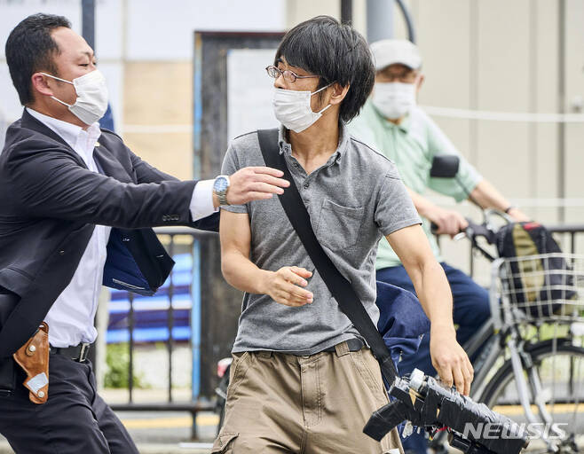 [나라(일본)=AP/뉴시스]지난 8일 일본 나라시에서 가두 연설을 하던 아베 신조 전 총리에게 총격을 가한 용의자 야마가미 데쓰야(41)가 현장에서 체포되고 있다. 범행에 사용한 것으로 보이는 총을 손에 쥐고 있다. 아베 전 총리는 병원으로 옮겨졌으나 사망했다. 2022.07.14.