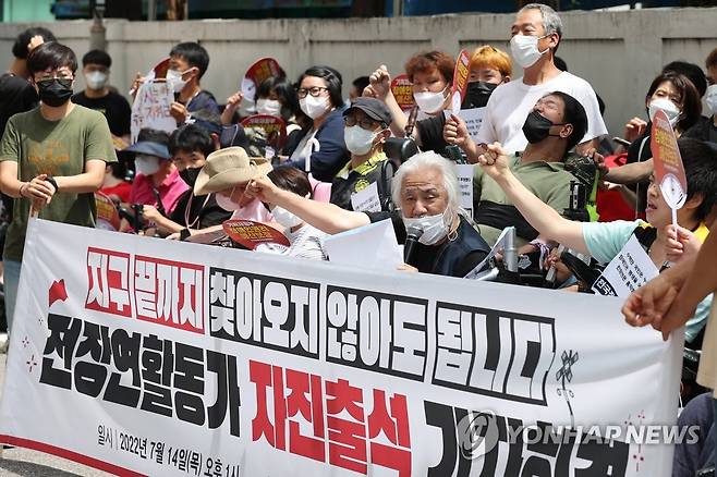 구호 외치는 전장연 (서울=연합뉴스) 신현우 기자 = 전국장애인차별철폐연대(전장연) 회원들이 14일 오후 서울 종로구 혜화경찰서 앞에서 열린 전장연 경찰 조사 자진출석 기자회견에서 구호를 외치고 있다.
    박경석 전장연 상임대표는 이날 혜화경찰서에 엘리베이터가 설치되면 경찰 조사에 임하겠다고 밝히며 양일홍 혜화서 경무과장에게 입장문을 전달했다. 2022.7.14 nowwego@yna.co.kr