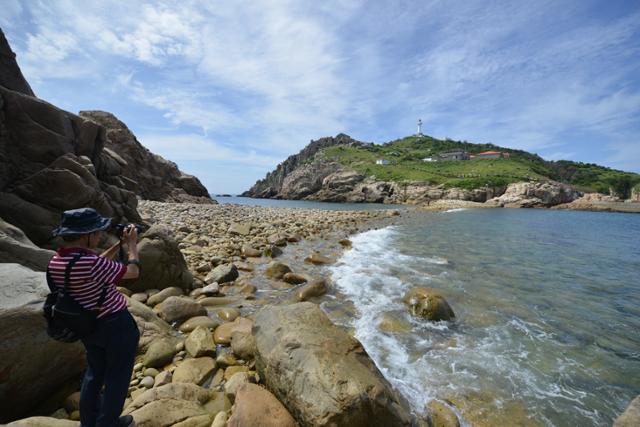 한 관광객이 소매물도와 몽돌해변으로 연결되는 등대섬을 카메라 렌즈에 담고 있다. 전준호 기자