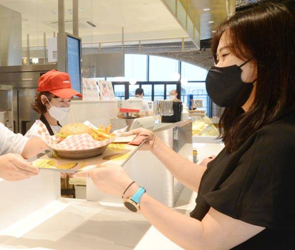 미국식 수제버거집인 파이어벨에서 고객이 음식을 건네받고 있다.